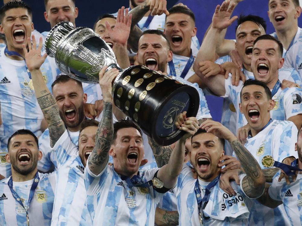 Argentina's Lionel Messi celebrates with the trophy after beating Brazil 1-0 in the Copa America final soccer match at Maracana stadium in Rio de Janeiro, Brazil, Saturday, July 10, 2021. Messi and Argentina will try to win their third straight major title when they defend their Copa America championship while Brazil hopes 17-year-old Endrick will combine with Vinícius Júnior and Rodrygo for success. (AP Photo/Bruna Prado, File)