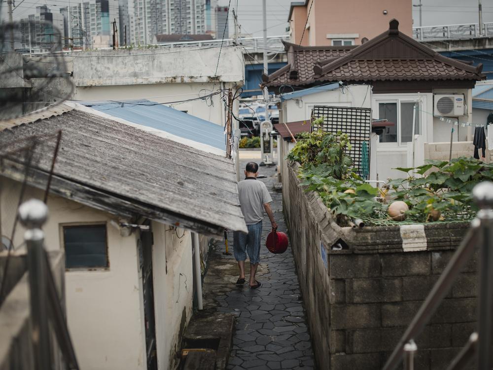 Kim Il-dong walks in his alleyway in Abai Village in Sokcho, South Korea, on Sept. 16, 2023.