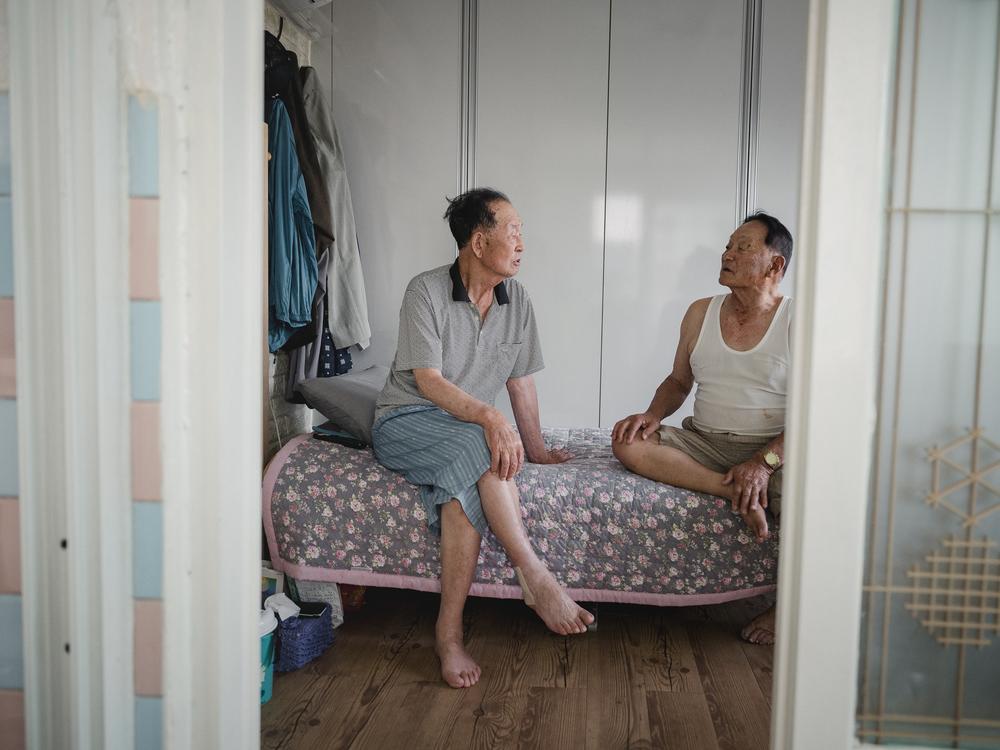 Kim Il-dong (left) and his friend, Kim Chul-hwan, sit together at Il-dong’s home in Abai Village in Sokcho, South Korea, on Sept. 11, 2023.