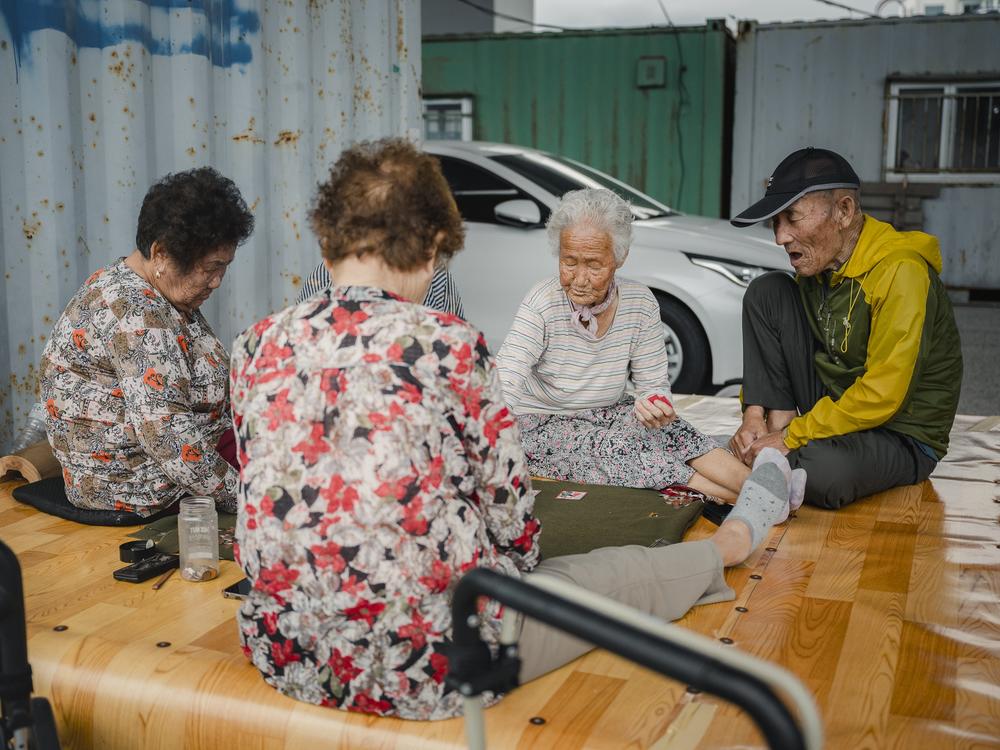 A group of friends, all seniors displaced from North Korea when they were young, play Go-Stop, a Korean card game, in Abai Village Sept. 10, 2023. Lee Hwa-ja (from left), Lim Joeng-ok, Lee Geum-soon and Choi Gi-hwal all lived in Korea's northern provinces before the country was divided. All fled with their families to escape the war, thinking they would eventually return home when the war ended.