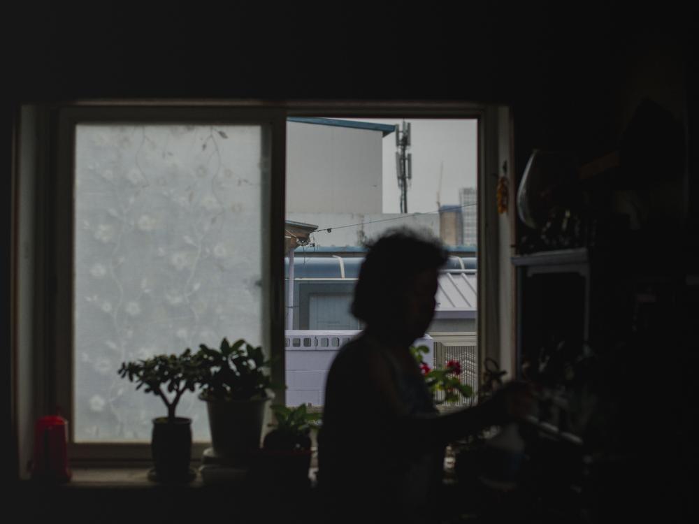 King Yong-jae, 82, is silhouetted by her window at her home in Sokcho, South Korea, on Sept. 14, 2023.