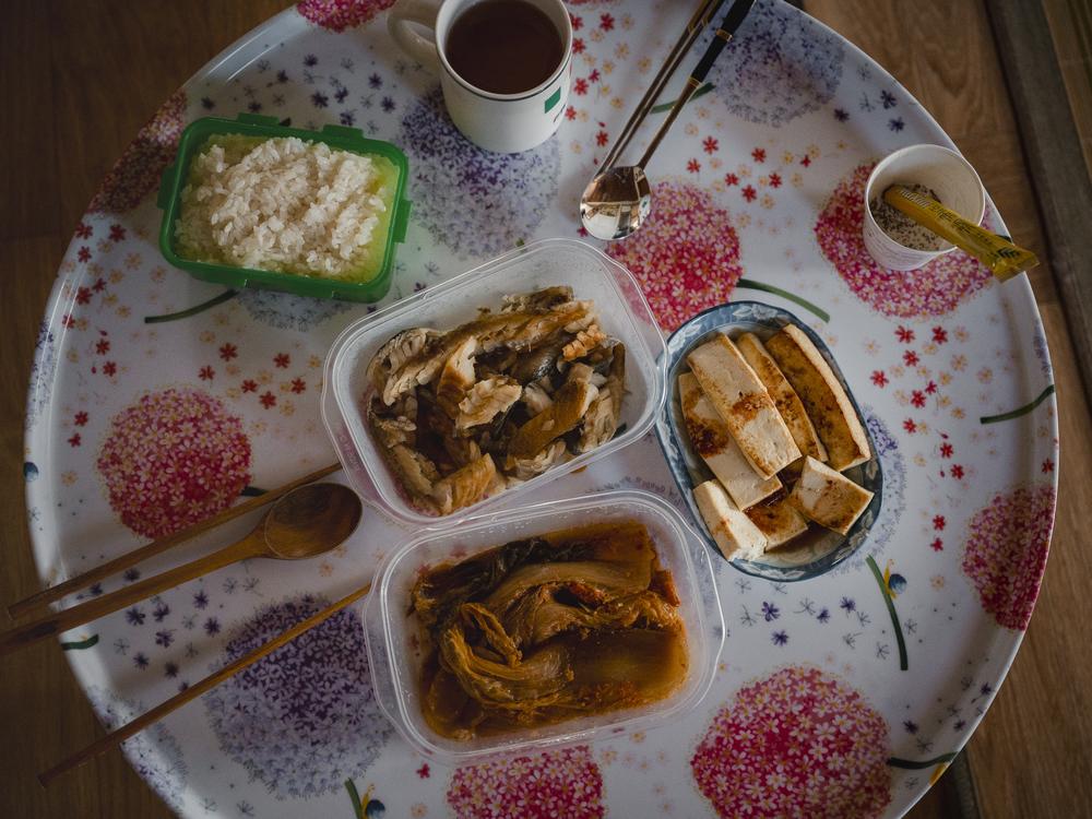 A meal of kimchi, fish, tofu and rice sits on a small dining table in Kim Yong-jae’s living room at her home in Sokcho, South Korea, on Sept. 11, 2023.