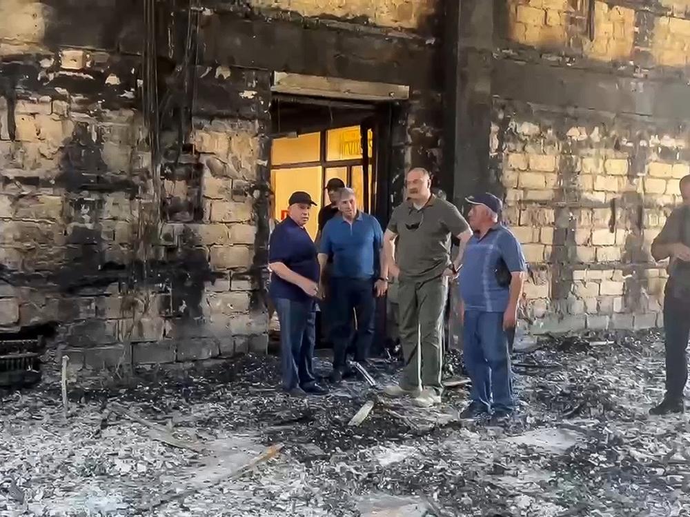 In this photo taken from video released by the Telegram channel of the head of Dagestan Republic of Russia on Monday, the head of Dagestan Republic, Sergei Melikov (center) visits the damaged Kele-Numaz synagogue in Derbent after an attack.