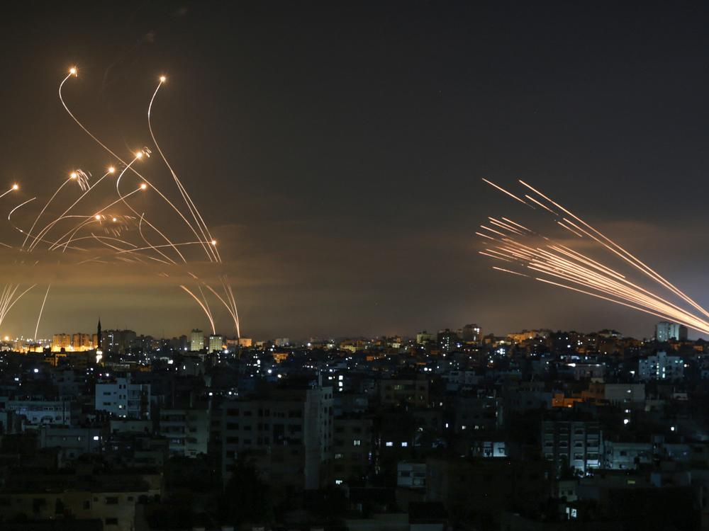 Israel's Iron Dome missile defense system (left) intercepts rockets (right) fired by Palestinian militants from Gaza on May 14, 2021. Over the years, Iron Dome has stopped thousands of rockets headed for Israeli cities, but experts warn that in a war with Hezbollah, new tactics and sheer numbers could cause it to fail.