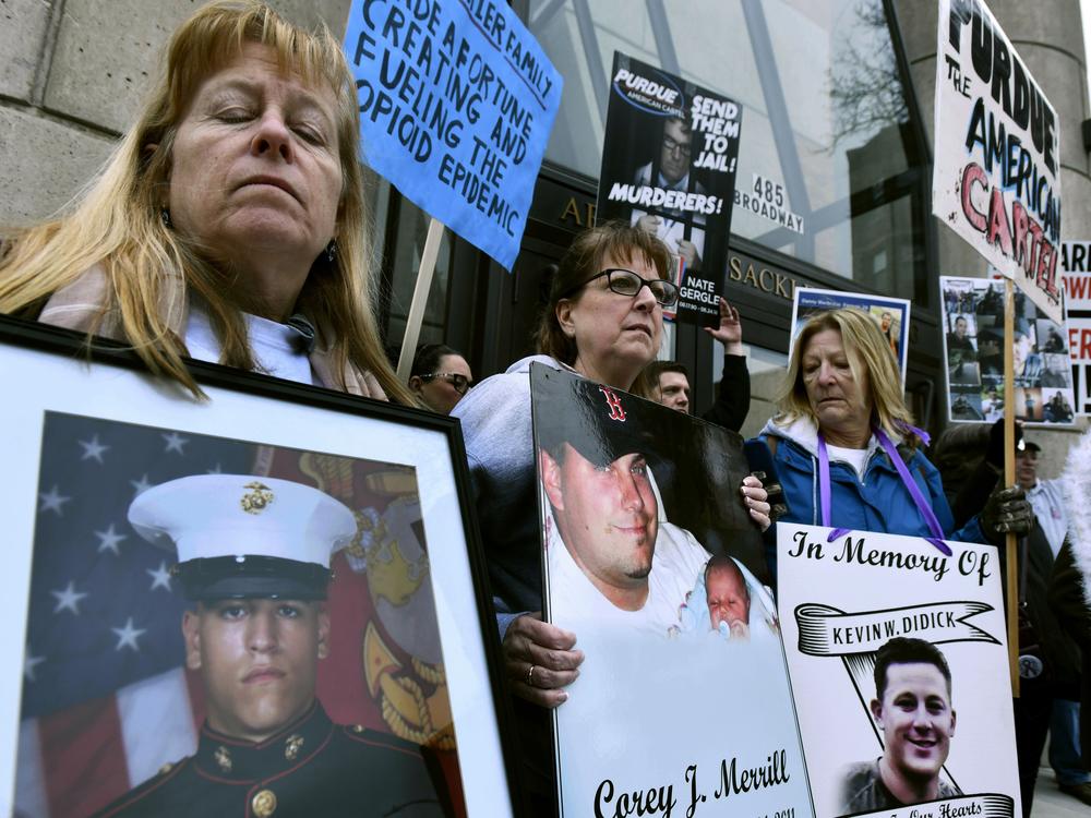 Kathleen Scarpone, left, of Kingston, N.H., and Cheryl Juaire, second from left, of Marlborough, Mass., attend a 2019 protest in front of the Arthur M. Sackler Museum, at Harvard University in Cambridge, Mass. Scarpone, who lost her son to OxyContin addiction, and Juarie addressed three Sackler family members during a virtual U.S. Bankruptcy Court hearing in March 2022.