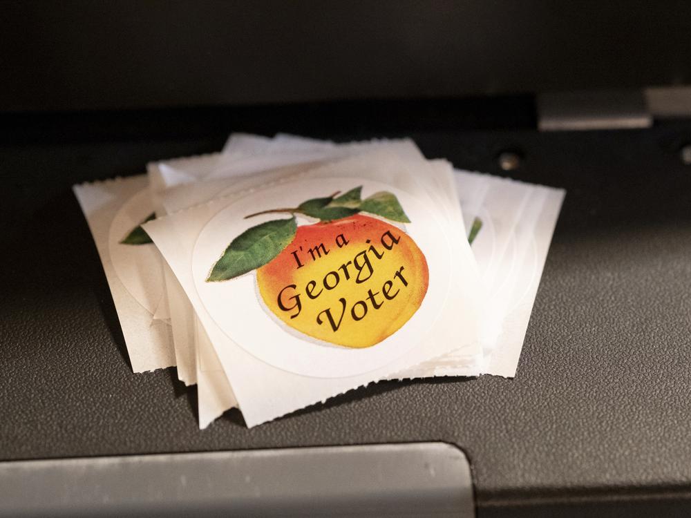 A stack of stickers sits atop a ballot scanner during the midterm elections on Nov. 8, 2022, in Tucker, Georgia. In 2024, Georgia is poised to play a pivotal role in the outcome of the presidential election. 