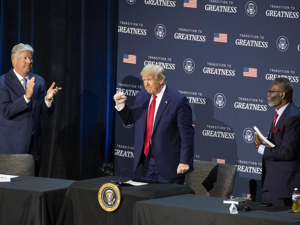 Pastor Robert Morris, left, and Bishop Harry Jackson, senior pastor at Hope Christian Church in Beltsville, Md., right, applaud after President Donald Trump spoke during a roundtable discussion about 