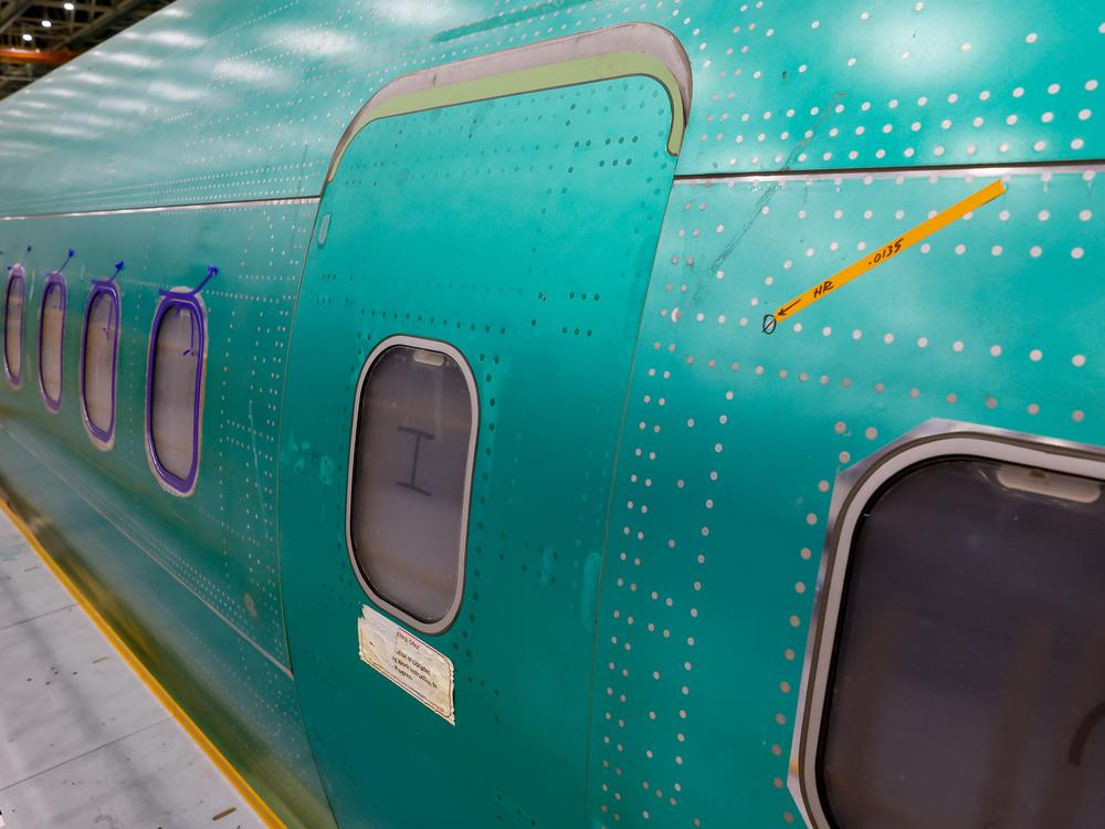 Orange tape points to a slightly raised rivet near a mid-cabin door plug on a 737 Max aircraft at the Boeing 737 factory in Renton, Wash., on Tuesday.