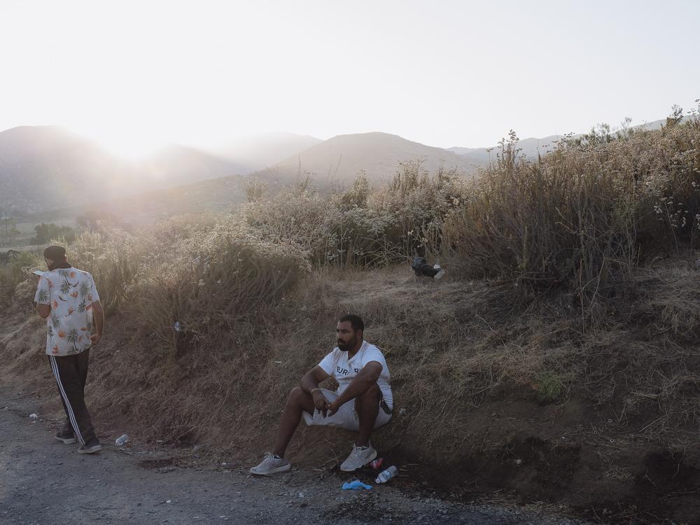 A couple of migrants wait to be processed by border patrol agents in Dulzara, California on June 25, 2024. 
