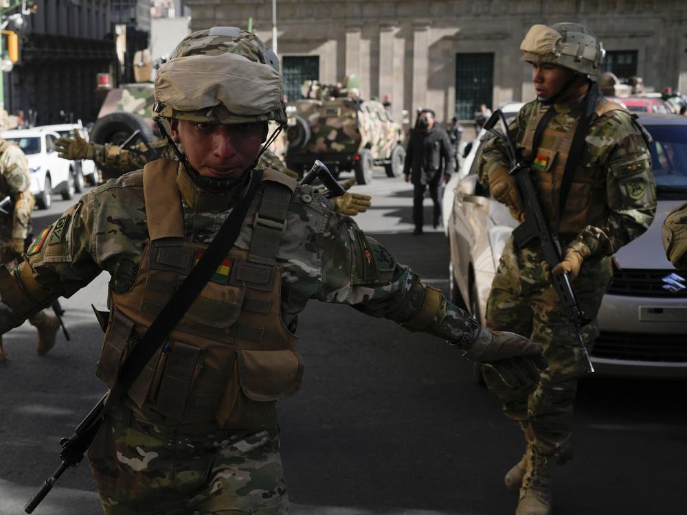 A soldier gestures for journalists to leave Plaza Murillo as soldiers gather outside the presidential palace in Plaza Murillo in La Paz, Bolivia, on Wednesday. Bolivian President Luis Arce warned that an “irregular” deployment of troops was taking place in the capital, raising concerns that a potential coup was underway. 