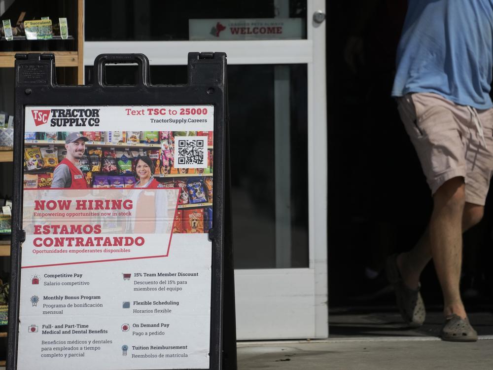 A sign in English and Spanish advertises jobs at a Tractor Supply store in Richland, Miss., in 2023.  