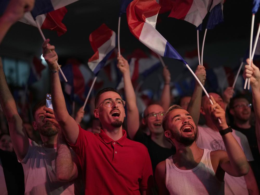 Supporters of French far-right leader Marine Le Pen react after vote projections in select constituencies, Sunday, in Henin-Beaumont, northern France. French voters propelled the far-right National Rally to a strong lead in first-round legislative elections Sunday and plunged the country into political uncertainty.