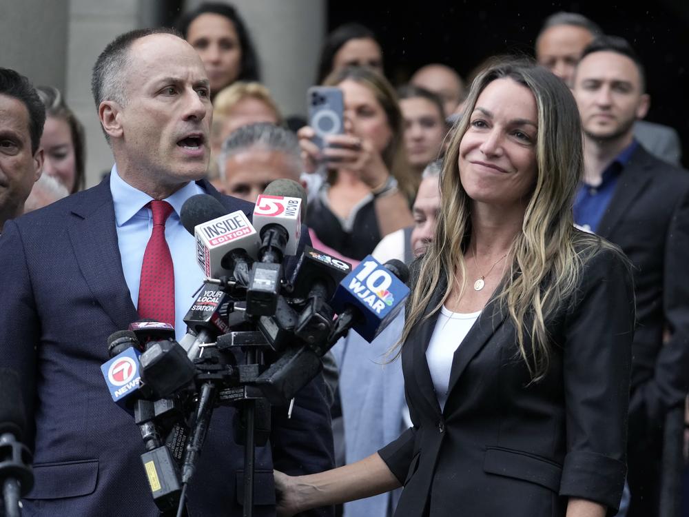 Karen Read, right, smiles as defense attorney David Yannetti, front left, speaks to reporters in front of Norfolk Superior Court in Dedham, Mass., after the judge declared a mistrial on Monday.