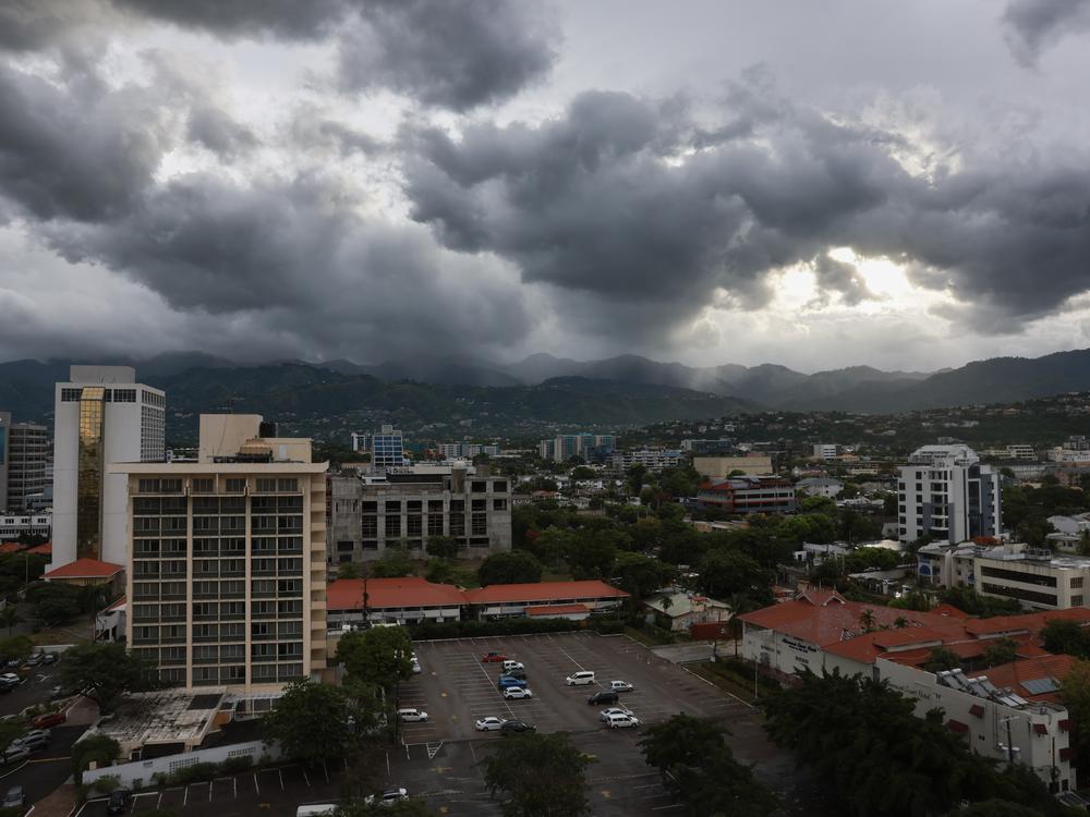 Storm clouds hover over the mountains as people make last-minute preparations for the arrival of Hurricane Beryl in Kingston, Jamaica on Wednesday.