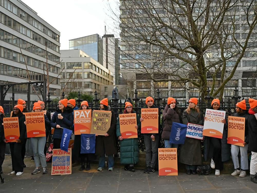 People hold British Medical Association branded placards calling for better pay on a picket line outside St. Thomas' Hospital in central London on Jan. 3, on the first day of a strike.