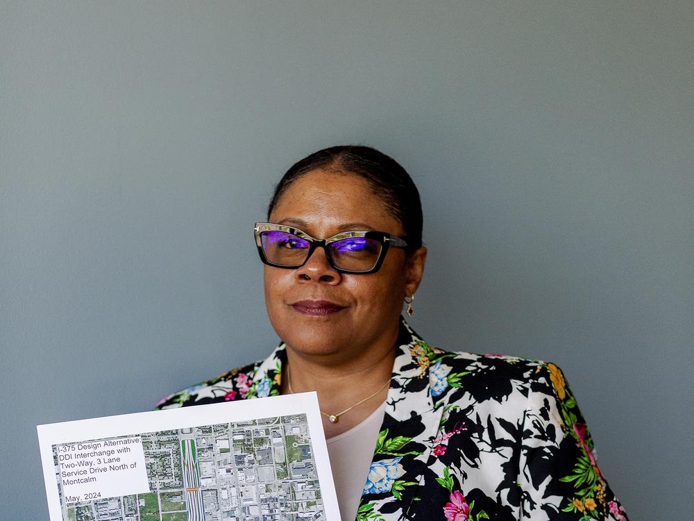 Love holds a rendering of the redesigned boulevard and highway interchange in Detroit on May 17. Some residents have criticized the plan as lacking a clear vision.