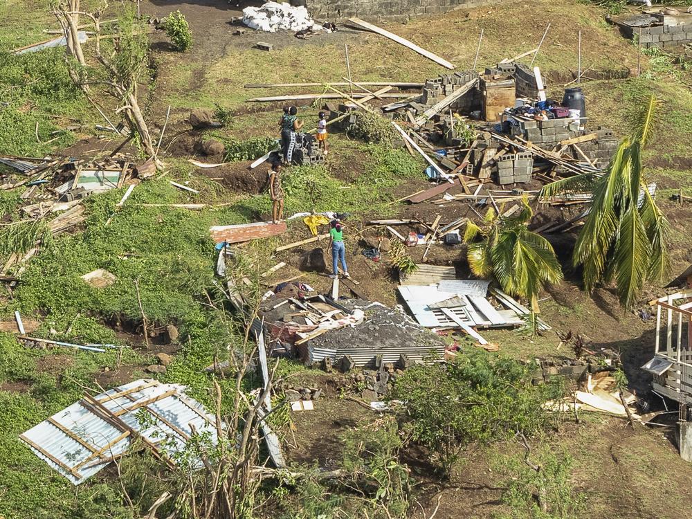Family members survey their home destroyed in the passing of Hurricane Beryl, in Ottley Hall, St. Vincent and the Grenadines, Tuesday, July 2, 2024.