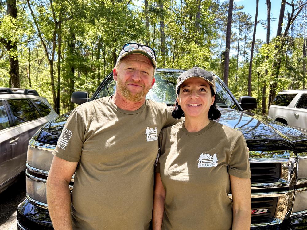 Chris Campbell, 49, maintains power lines; his girlfriend Angie Sutton, 46, is an auditor and retired from the Air Force. They were interviewed in Suwannee River State Park in Florida, wearing T-shirts that read “The People ARE PISSED OFF.”<br>