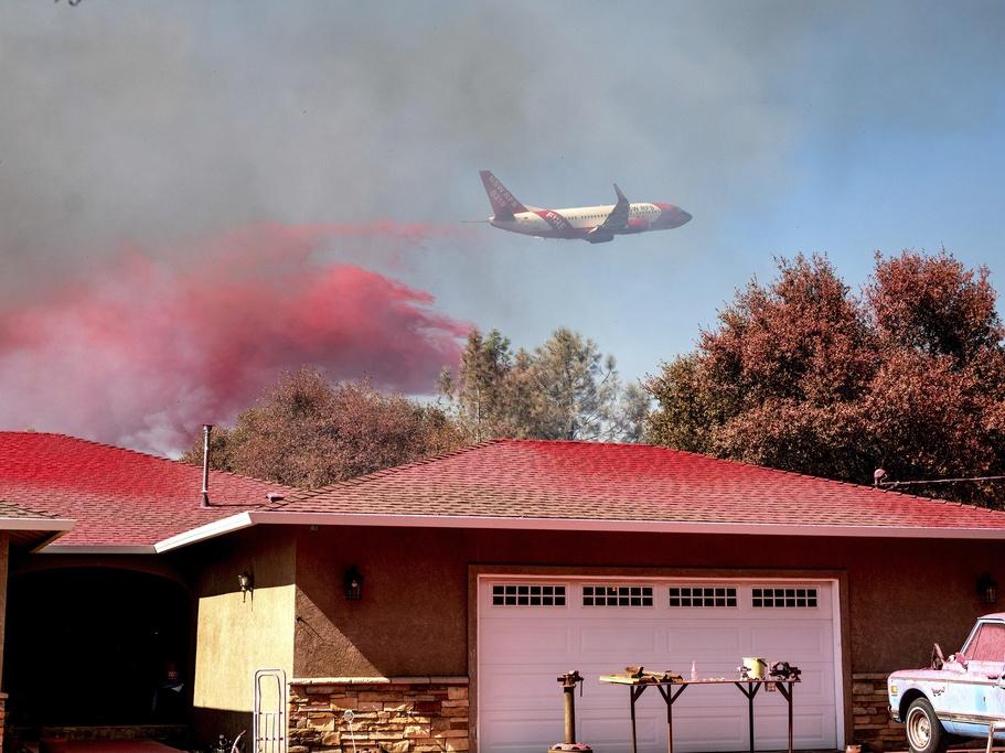 An air tanker drops fire retardant while trying to keep the Grubbs Fire from spreading in the Palermo community of Butte County, Calif., on Wednesday. Firefighters stopped the fire at around 10 acres, but the Thompson fire near Oroville, Calif., is still burning.