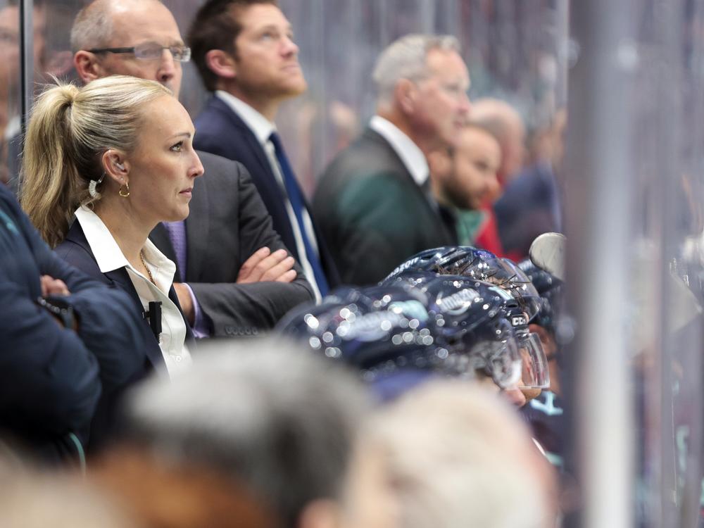 Jessica Campbell (left) was the assistant coach for the Coachella Valley Firebirds, working alongside Seattle Kraken coaches behind the bench during the second period of an NHL preseason hockey game against the Calgary Flames on Sept. 25 in Seattle.