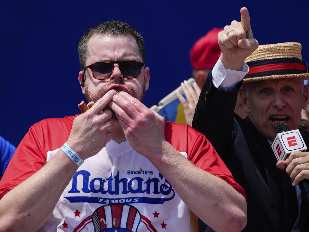 Patrick Bertoletti stuffs hot dogs into his mouth during the men's division in Nathan's Famous Fourth of July hot dog eating contest, Thursday, at Coney Island in the Brooklyn borough of New York. Bertoletti ate 58 hot dogs.