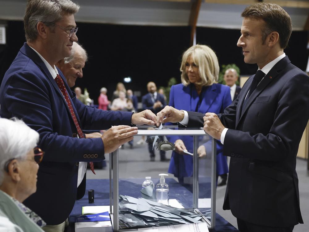 French President Emmanuel Macron, right, votes for the second round of the legislative elections in Le Touquet-Paris-Plage, northern France, on Sunday. 