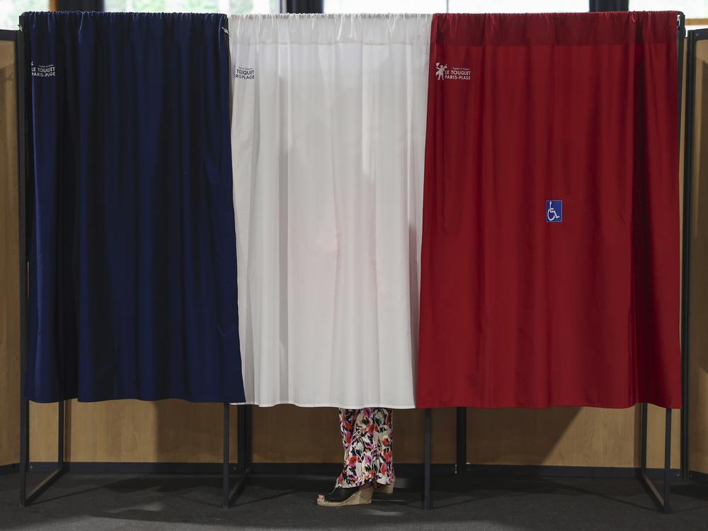 A voter stands in the polling booth during the second round of the legislative elections in Le Touquet-Paris-Plage, northern France, on Sunday. 