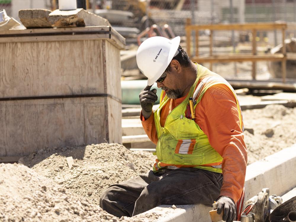 A worker adjusts his helmet on a construction site under the sun as southern California faces a heat wave, in Los Angeles, on Wednesday.