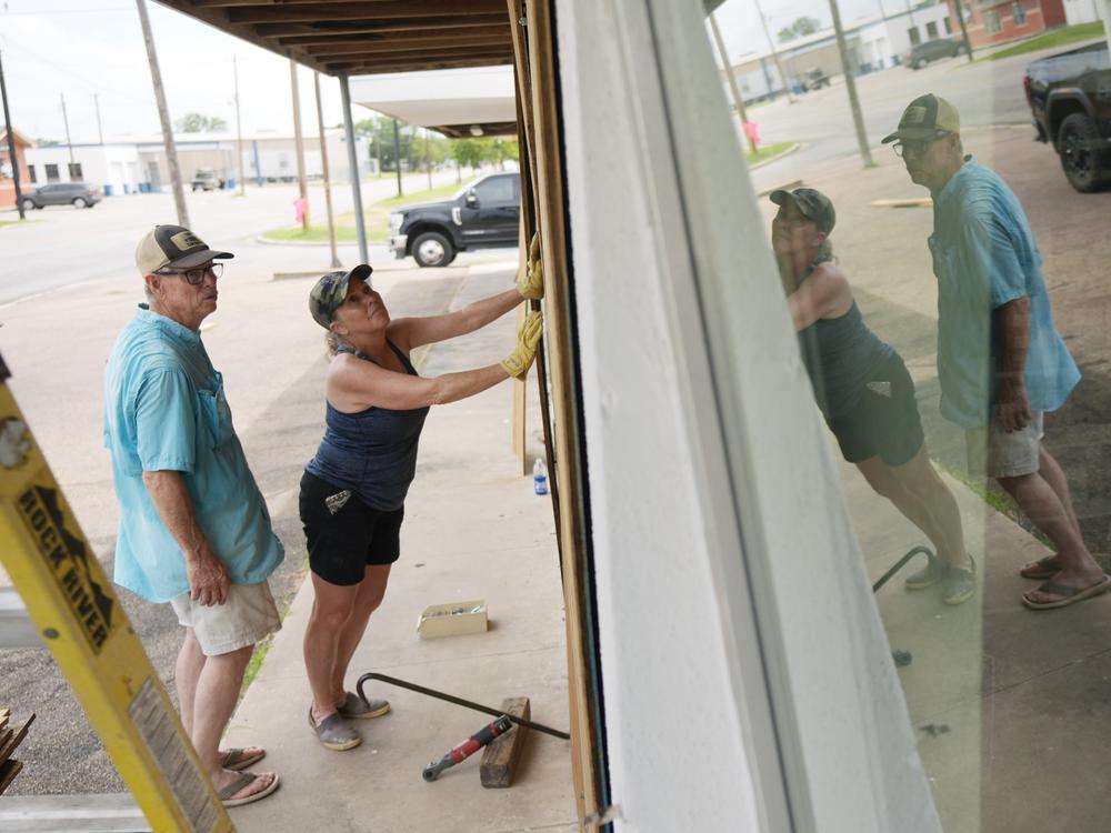 Sherry Cothron and Jimmy May board windows as they prepare for Hurricane Beryl's arrival, Sunday, July 7, 2024, in Port Lavaca, Texas.