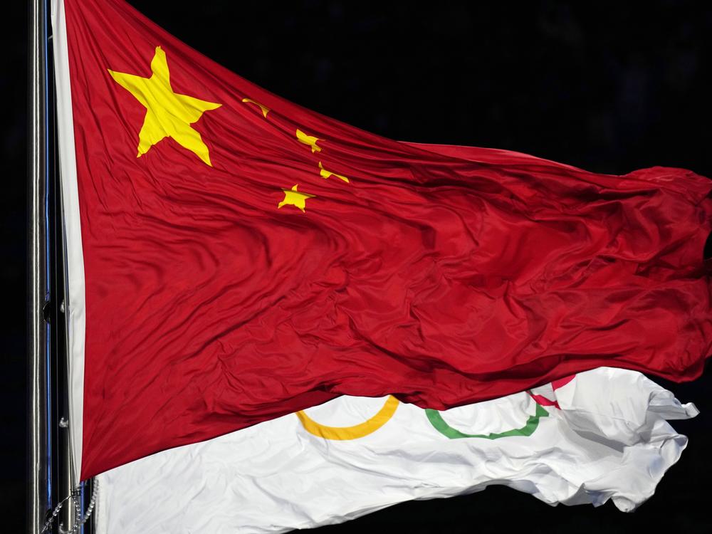 The Chinese and the Olympic flag wave during the opening ceremony of the 2022 Winter Olympics in Beijing. The World Anti-Doping Agency cleared 23 Chinese swimmers of doping allegations despite positive tests for banned substances, allowing them to compete in the 2021 Tokyo Games.
