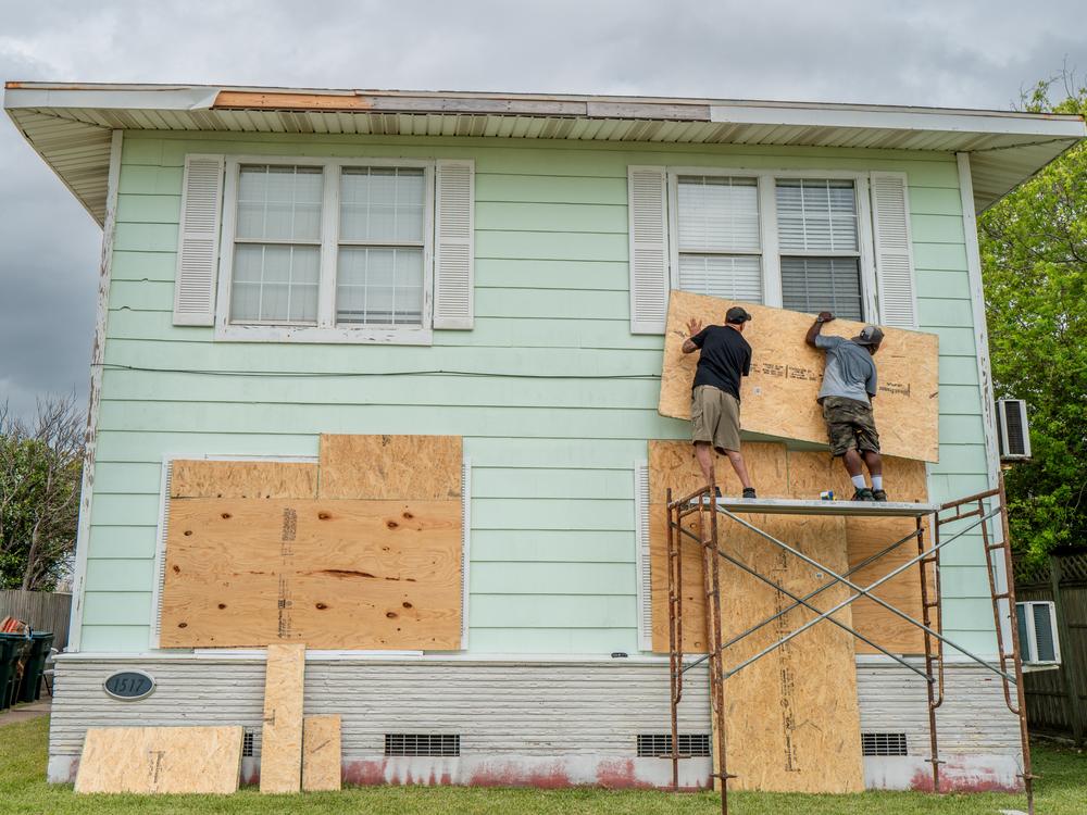 Dane Allen and Randy Davis board up apartments on Sunday ahead of Beryl's arrival in Corpus Christi, Texas.