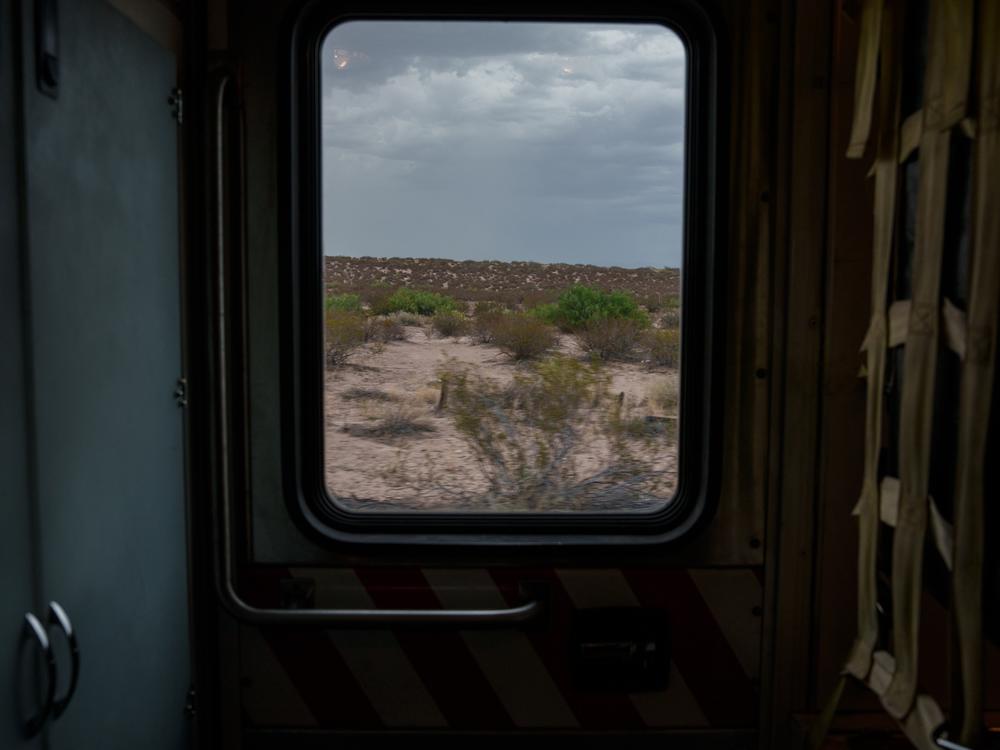 The open desert is seen through the window of a Sunland Park Fire Department ambulance as firefighters respond to a call in Santa Teresa, N.M., on Saturday, June 29, 2024. 