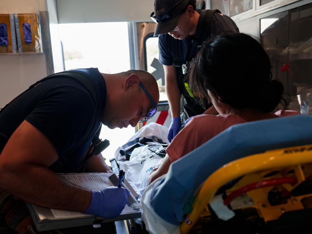 Sunland Park Fire Department driver Luis Márquez, 39, takes notes from a patient from Ecuador who was being treated for heat-related illness in Santa Teresa, N.M., on Saturday, June 29, 2024. The department responded to a call at the Santa Teresa Border Patrol station after the U.S. Border Patrol apprehended six individuals who had heat-related illnesses. 