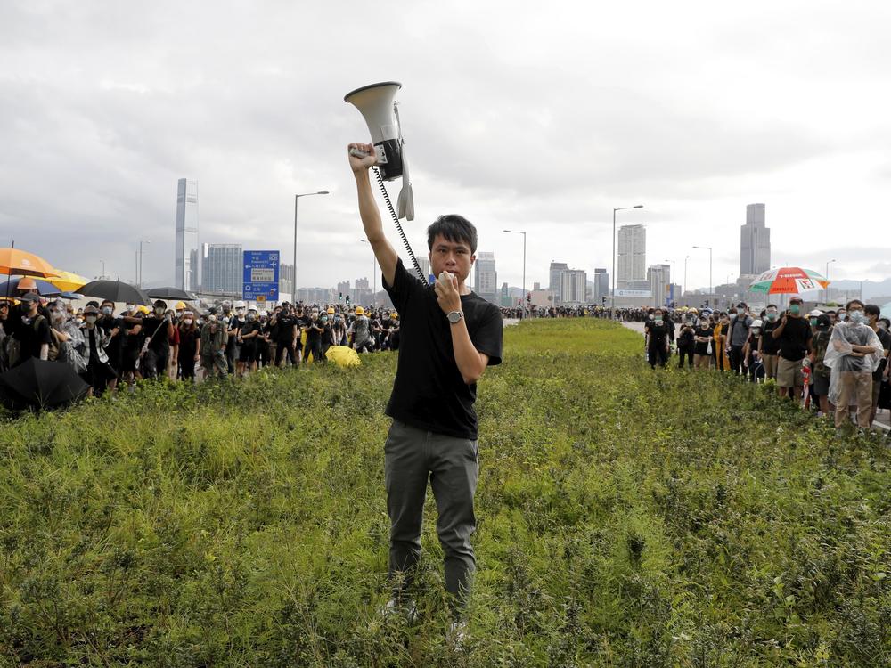Roy Kwong Chun-yu, a pro-democracy member of Hong Kong's Legislative Council at the time, spoke over a loud-hailer to the police as he joined protesters in Hong Kong on July 1, 2019. Demonstrators pushed barriers and dumpsters into the streets in an apparent bid to block access to a ceremony marking the anniversary of the handover of the former British colony to China.