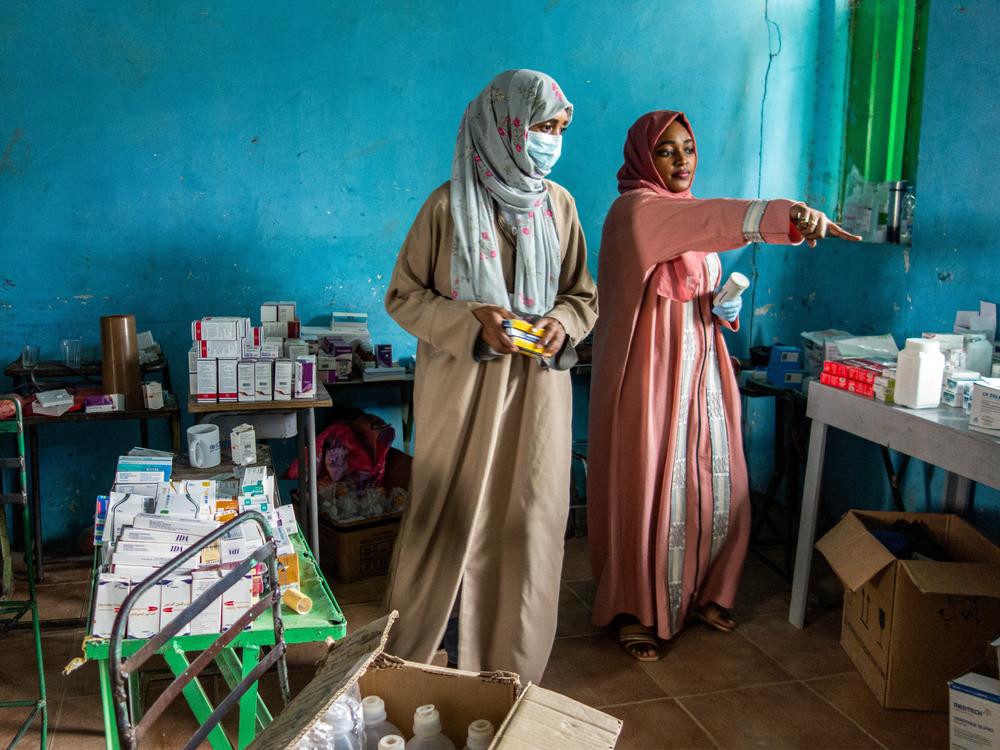 On July 6, volunteers dispense medication at a makeshift emergency clinic, set up in a former school in eastern Sudan, for people displaced by conflict.