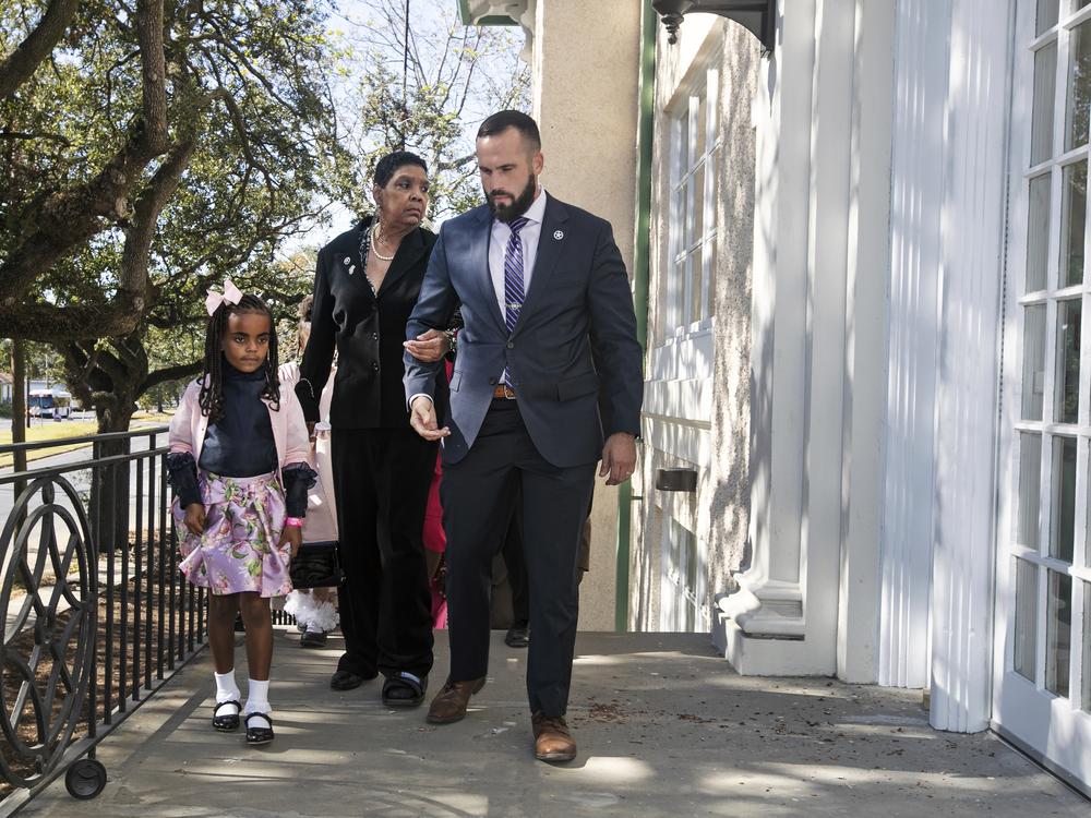 Tessie Prevost, center, and 7-year-old Elan Jolie Hebert are escorted by U.S. Marshal Michael Atkins up the steps of McDonogh 19 Elementary School as Prevost was escorted in 1960, during a New Orleans 61st anniversary ceremony in 2021. Prevost was one of the first African-American women who integrated the all-white public schools in New Orleans.