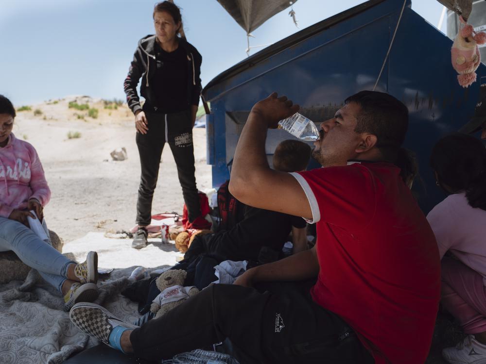 Asylum seekers from Michoacán, Mexico, try to stay cool as they wait for border patrol agents in Jacumba Hot Springs, California on June 24, 2024. 