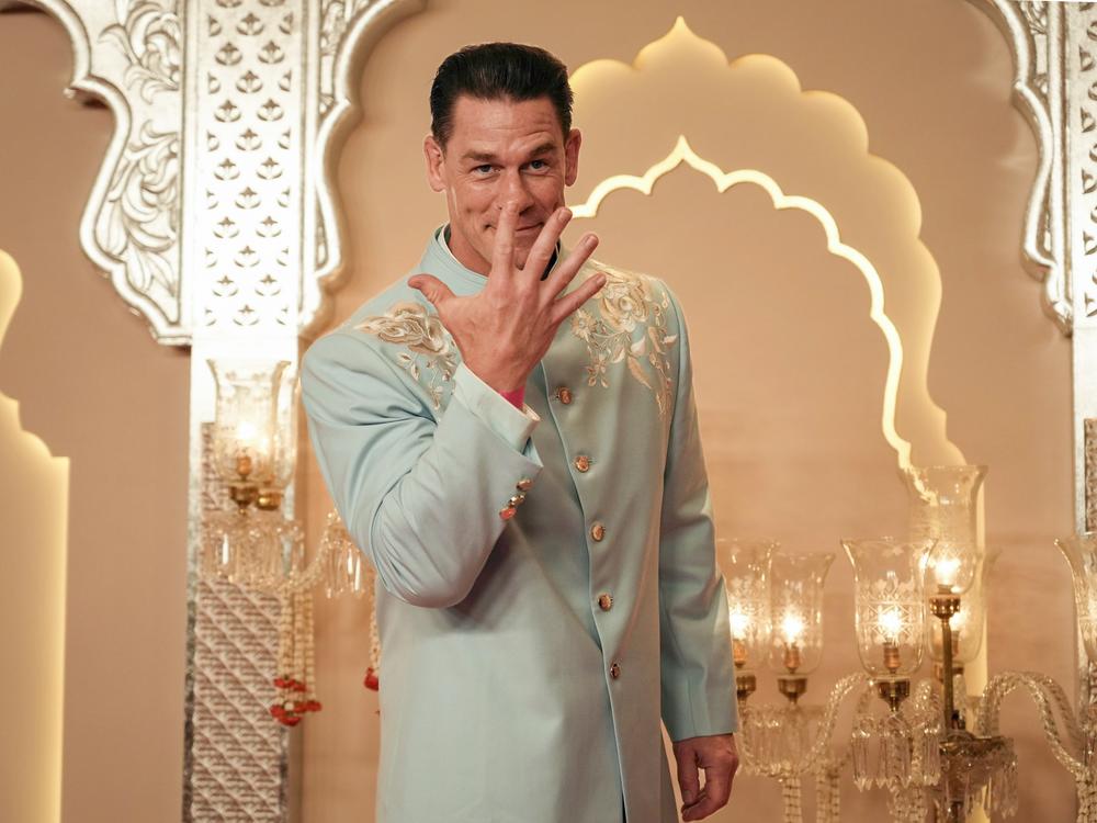 American actor and professional wrestler John Cena gestures as he arrives at the wedding in Mumbai on Friday.