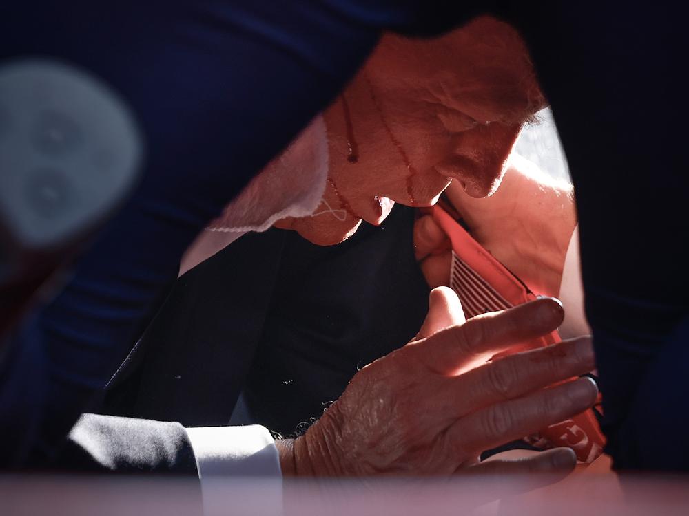 Republican presidential candidate former President Trump is shown covered by U.S. Secret Service agents after an incident.