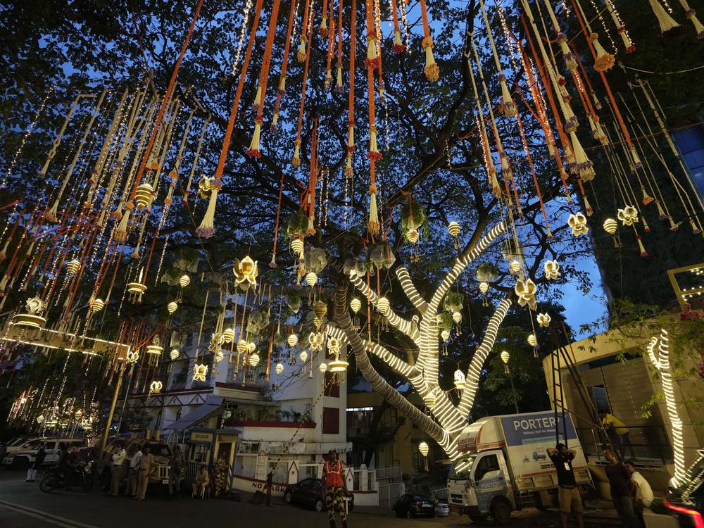 People walk past the Antilia mansion, house of billionaire Mukesh Ambani, while it is lit up ahead of his son Anant Ambani and Radhika Merchant's wedding in Mumbai on Wednesday.