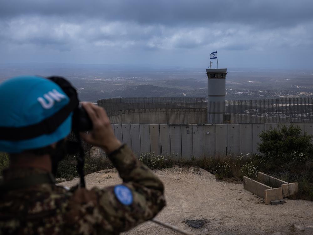  A UNIFIL member of the Italian contingent observes an Israeli position from a watchtower inside his base at the blue line between Lebanon and Israel.