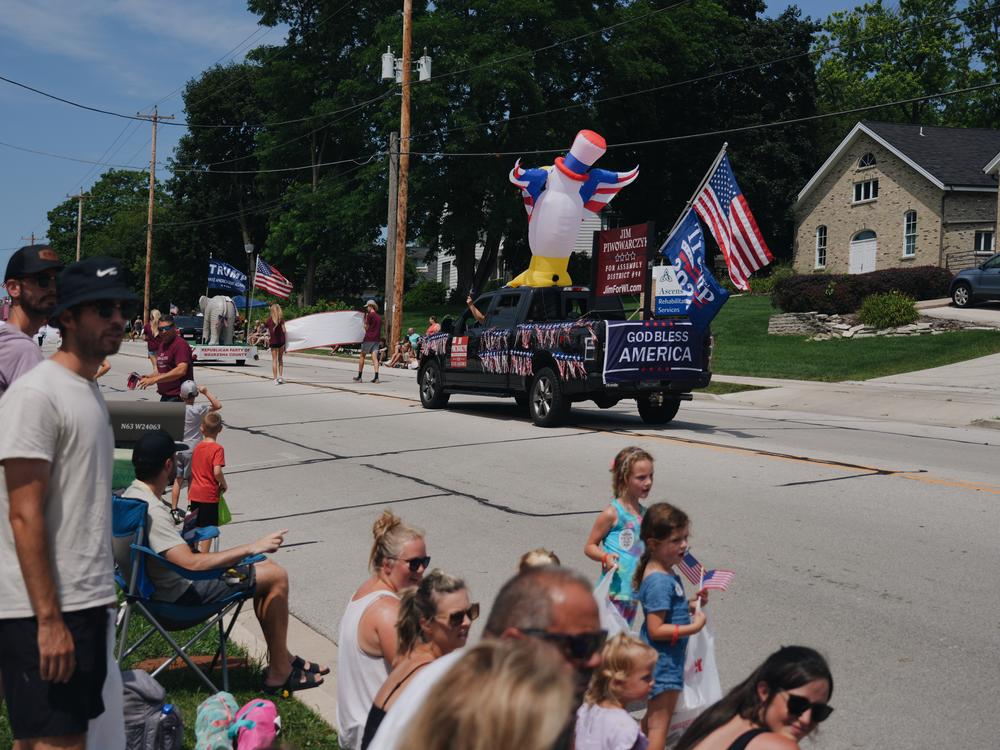 An American flag and a Trump 2024 flag seen flying on the back of a truck during during the annual Lions Daze parade on Sunday morning in Sussex in Waukesha County.