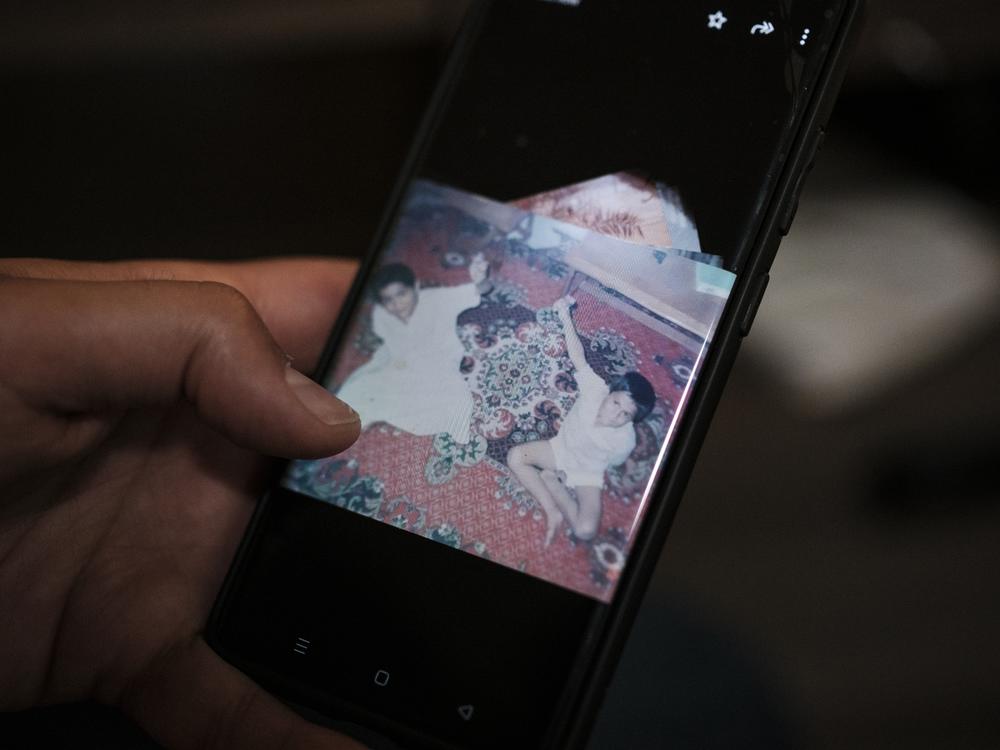 Hani looks at a photo of him and his brother Majed on his phone. Majed was killed by a bomb in November, along with his wife and their four children.