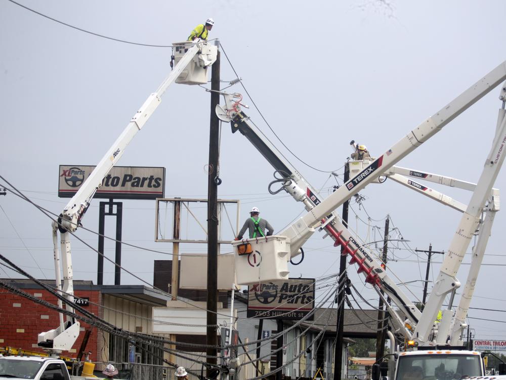 Utility crews work to restore electricity in Houston on Thursday. Prolonged outages following Hurricane Beryl has some fed-up and frustrated residents taking out their anger on repair workers who are trying to restore power.