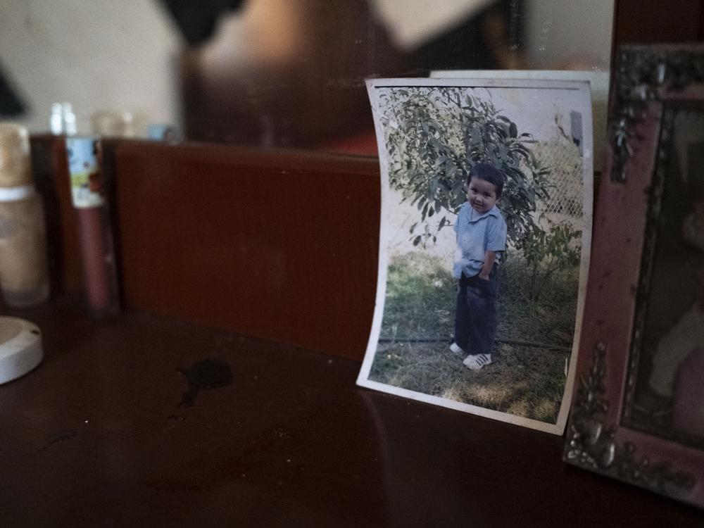 A photo of Kevin as a child stands on a table in his family’s abandoned house in Michoacán, Mexico on November 14, 2022. The house has remained abandoned and all their belongings remain in the same place.