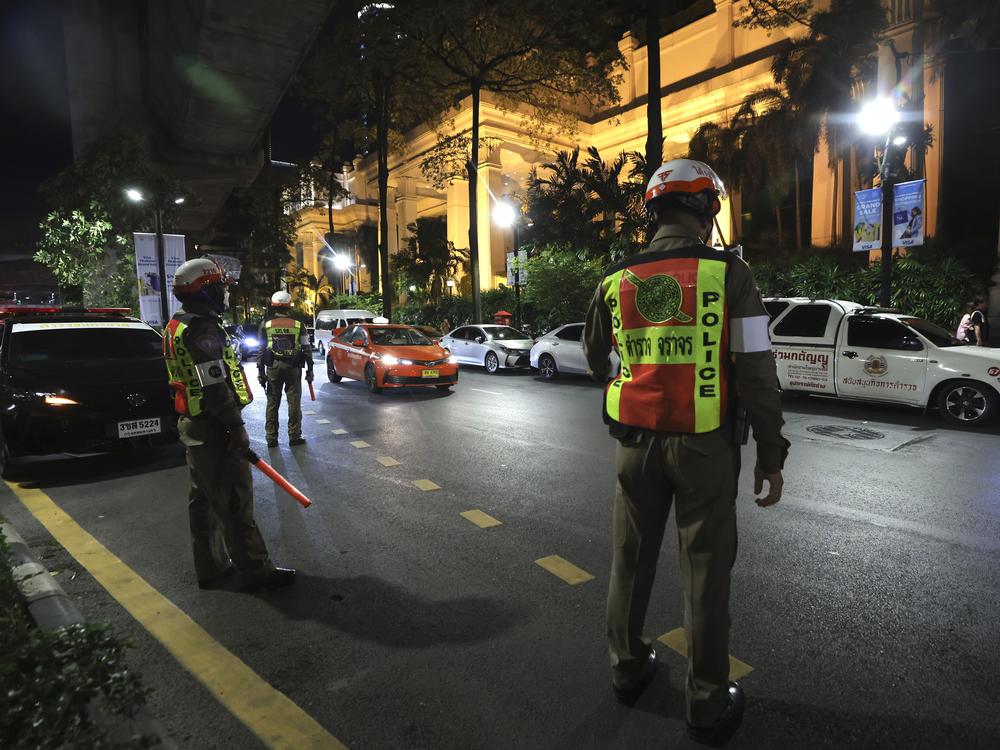 Police officers stand outside the Grand Hyatt Erawan Hotel in Bangkok, Thailand, on Tuesday. Police said a number of people were found dead Tuesday in the luxury hotel in downtown Bangkok and poisoning is suspected.