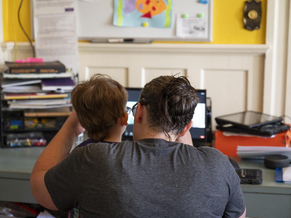 Six-year-old Sam and his mother, Tabitha, attend a virtual class with Sam’s teacher of the deaf and hard of hearing.
