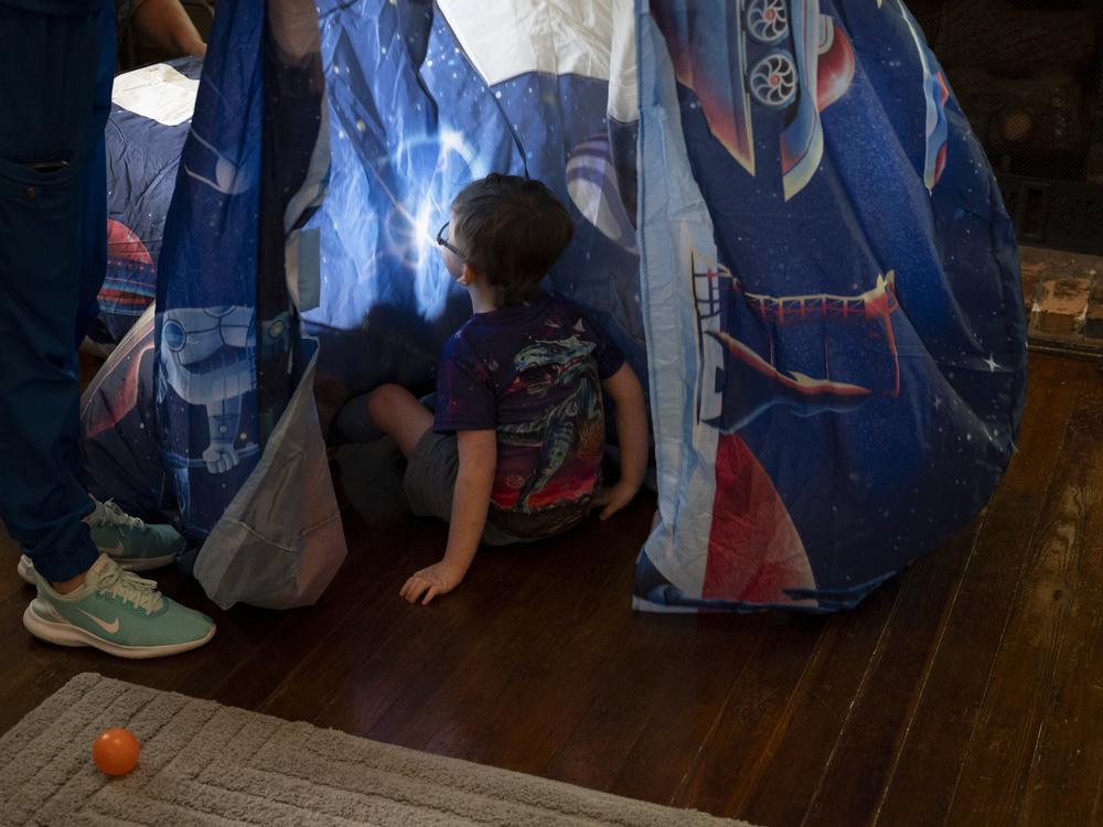 Sam plays in a tent in his playroom.