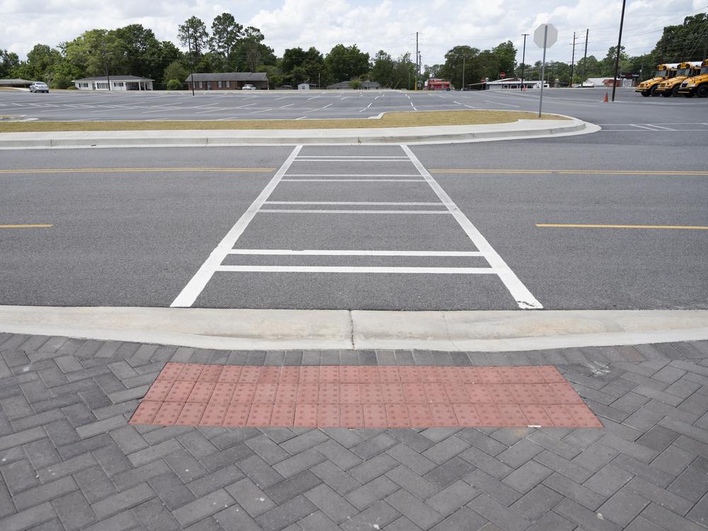 Tabitha and John’s formal complaint against their child’s school district includes concerns about accessibility for students with disabilities to parts of the campus. One example is a crosswalk with a curb cutout for wheelchair access on one side, and no cutout on the other.