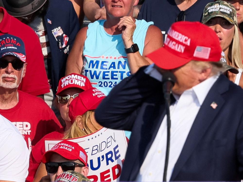 Republican presidential candidate Donald Trump reaches for his right ear as multiple shots ring out during the campaign rally in Butler on July 13.
